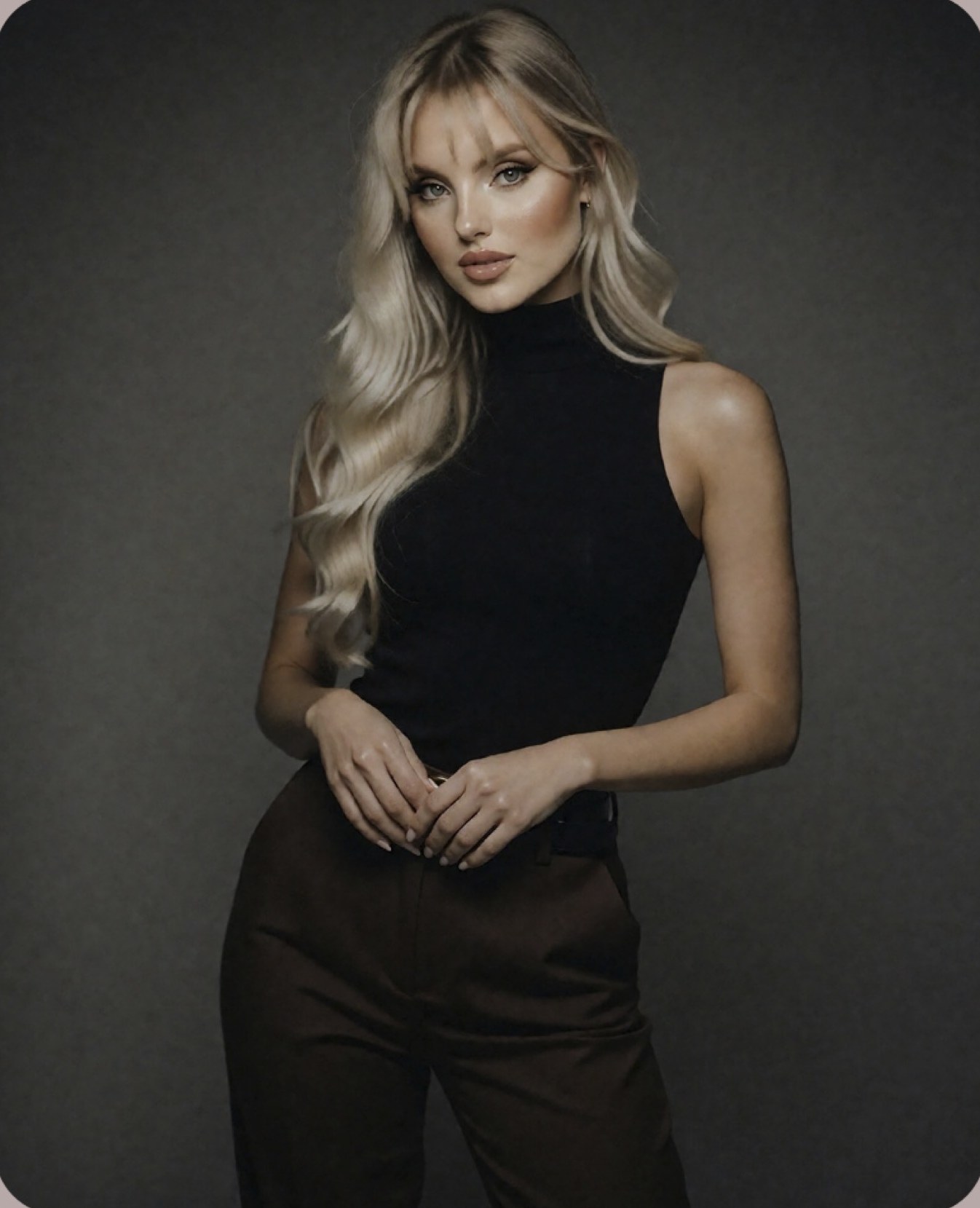 Allison Hernandez in a black sleeveless top and brown trousers.